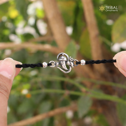 Sterling silver Lord Ganesha "Aum" OM design thread rakhi bracelet with intricate details, ideal for religious celebrations.