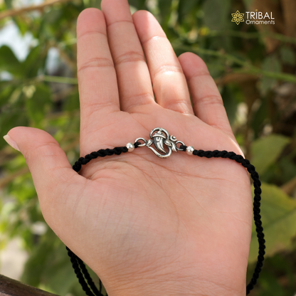 Sterling silver Lord Ganesha OM design thread rakhi bracelet with intricate details, handcrafted by TRIBAL ORNAMENTS.
