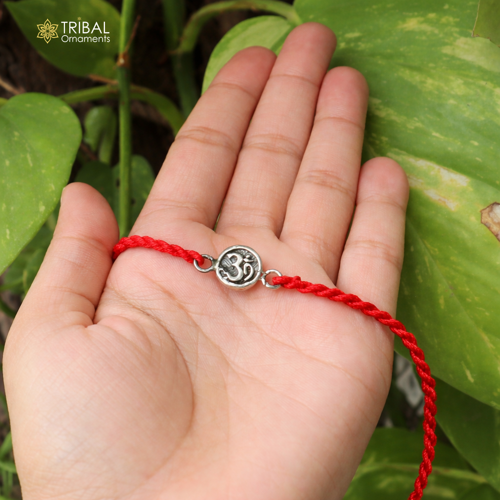 Sterling silver Hindu mantra "Aum" OM thread rakhi bracelet with intricate design by TRIBAL ORNAMENTS, perfect for religious ceremonies.
