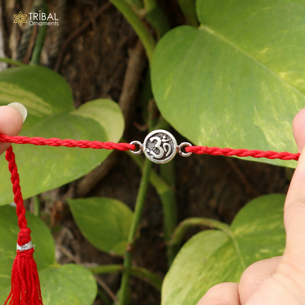 Sterling silver Hindu mantra "Aum" OM design thread rakhi bracelet with intricate details, crafted by TRIBAL ORNAMENTS.