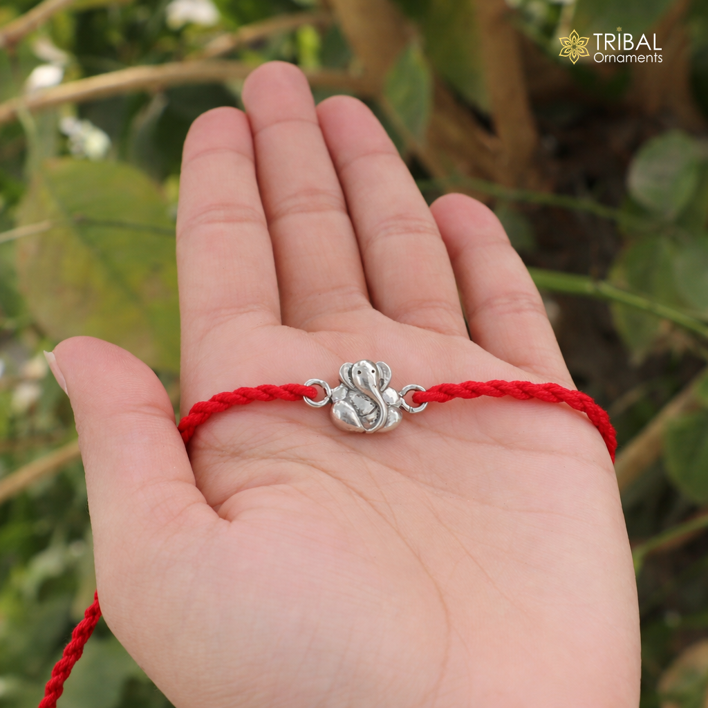 Sterling silver Lord Ganesha thread rakhi bracelet by TRIBAL ORNAMENTS featuring intricate Ganesha design on a silver bracelet.