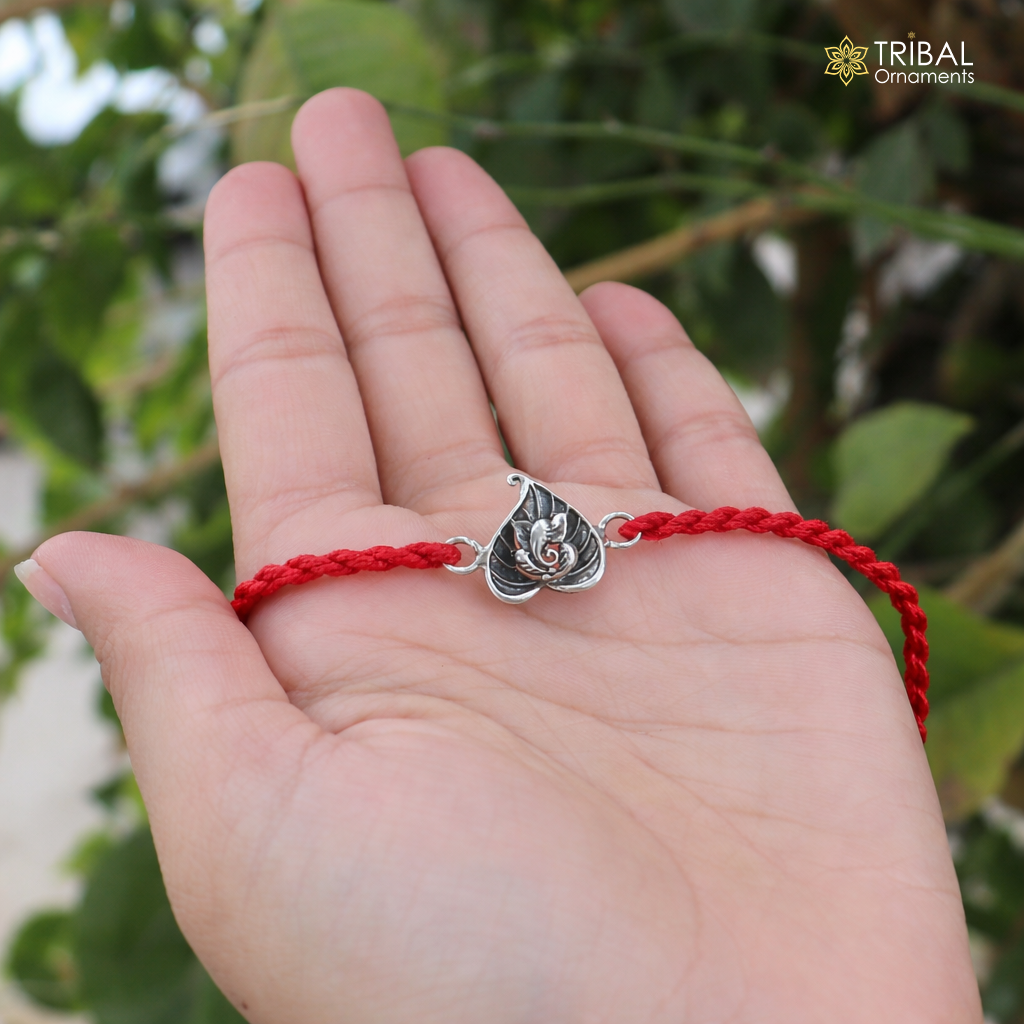 Sterling silver Lord Ganesha with pan design thread rakhi bracelet by TRIBAL ORNAMENTS, featuring intricate craftsmanship.