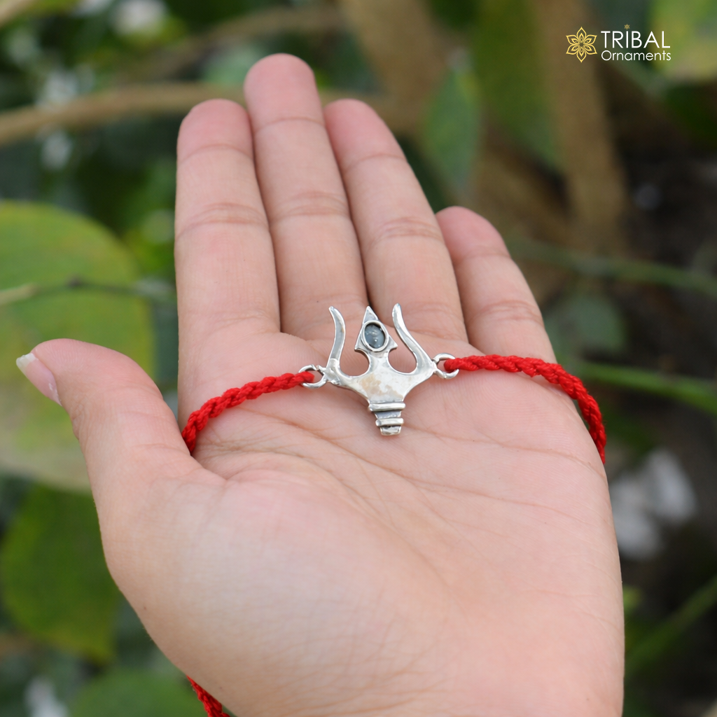 925 sterling silver Trishul thread rakhi bracelet with Trident design from TRIBAL ORNAMENTS, featuring intricate silver craftsmanship.