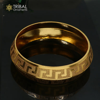 Stylish 999 pure silver gold-polished heavy bangle kada by TRIBAL ORNAMENTS, featuring intricate tribal design and polished finish.