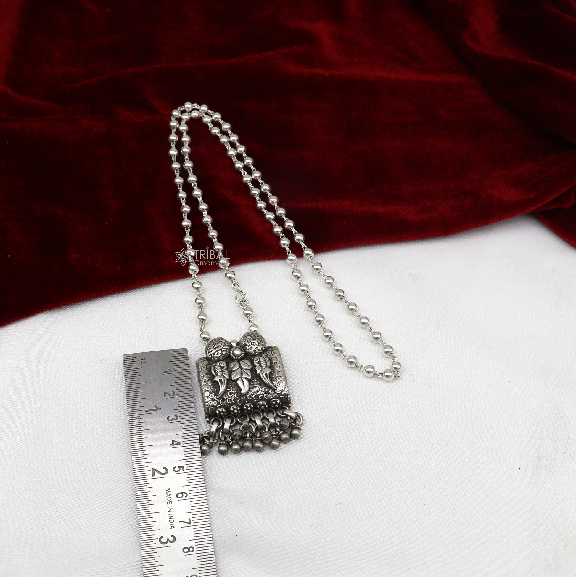 Sterling silver bird pendant with intricate tribal design on beaded necklace, perfect for all outfit styles.
