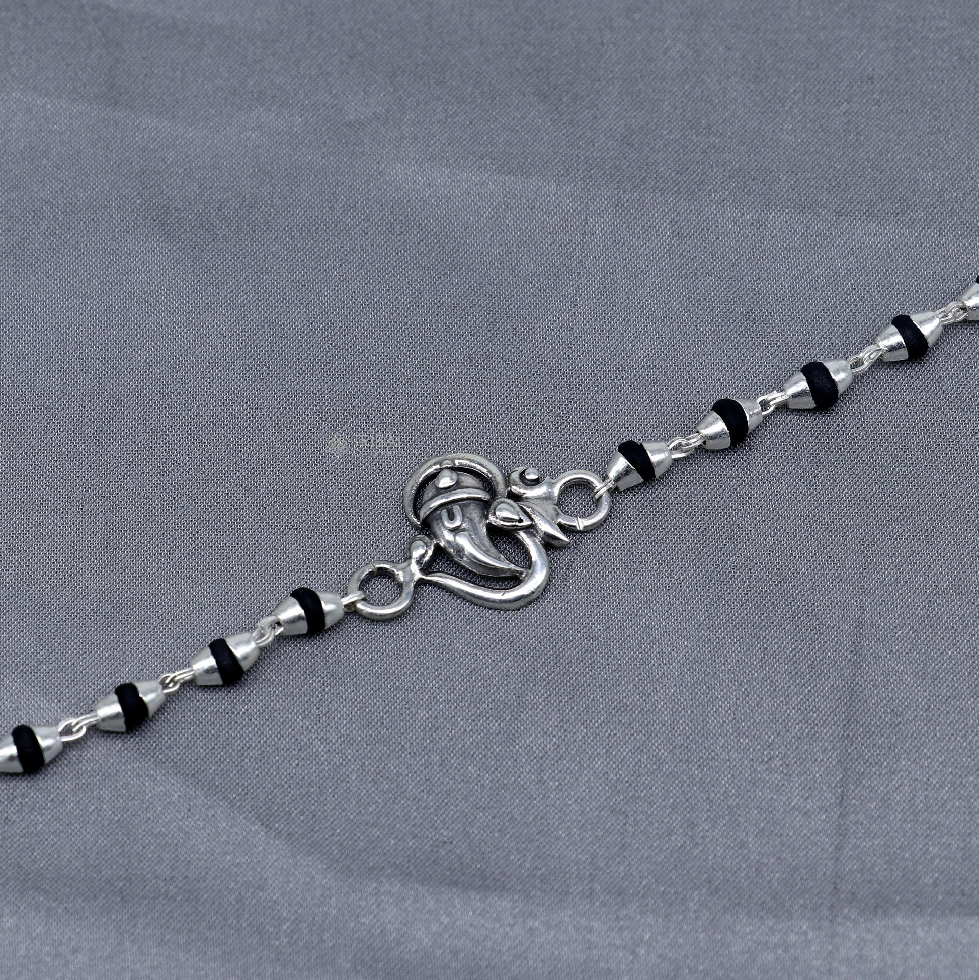 Sterling silver Lord Ganesha bracelet with black Tulsi beads, handmade Hindu prayer beads and rakhi from Tribal Ornaments.