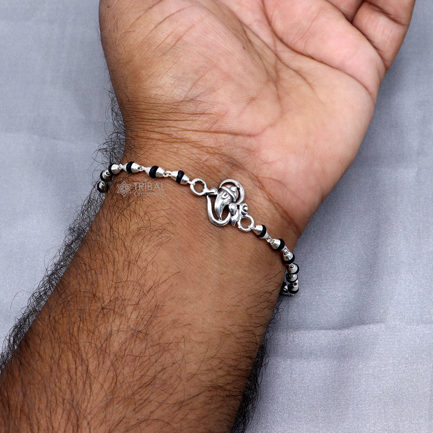 Sterling silver Lord Ganesha bracelet with black Tulsi beads, handmade tribal design, sacred rosary-style jewelry for spiritual blessing.