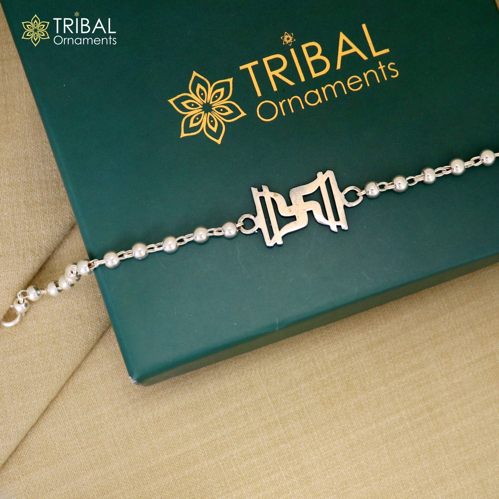 Sterling silver Swastik design Rudraksh and black tulsi bead bracelet rakhi with silver beads and intricate tribal ornament details.