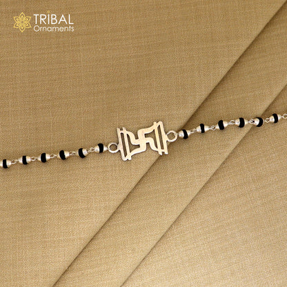 Sterling silver Swastik design Rudraksha and black tulsi beads bracelet rakhi with silver beads, intricate tribal ornament craftsmanship.