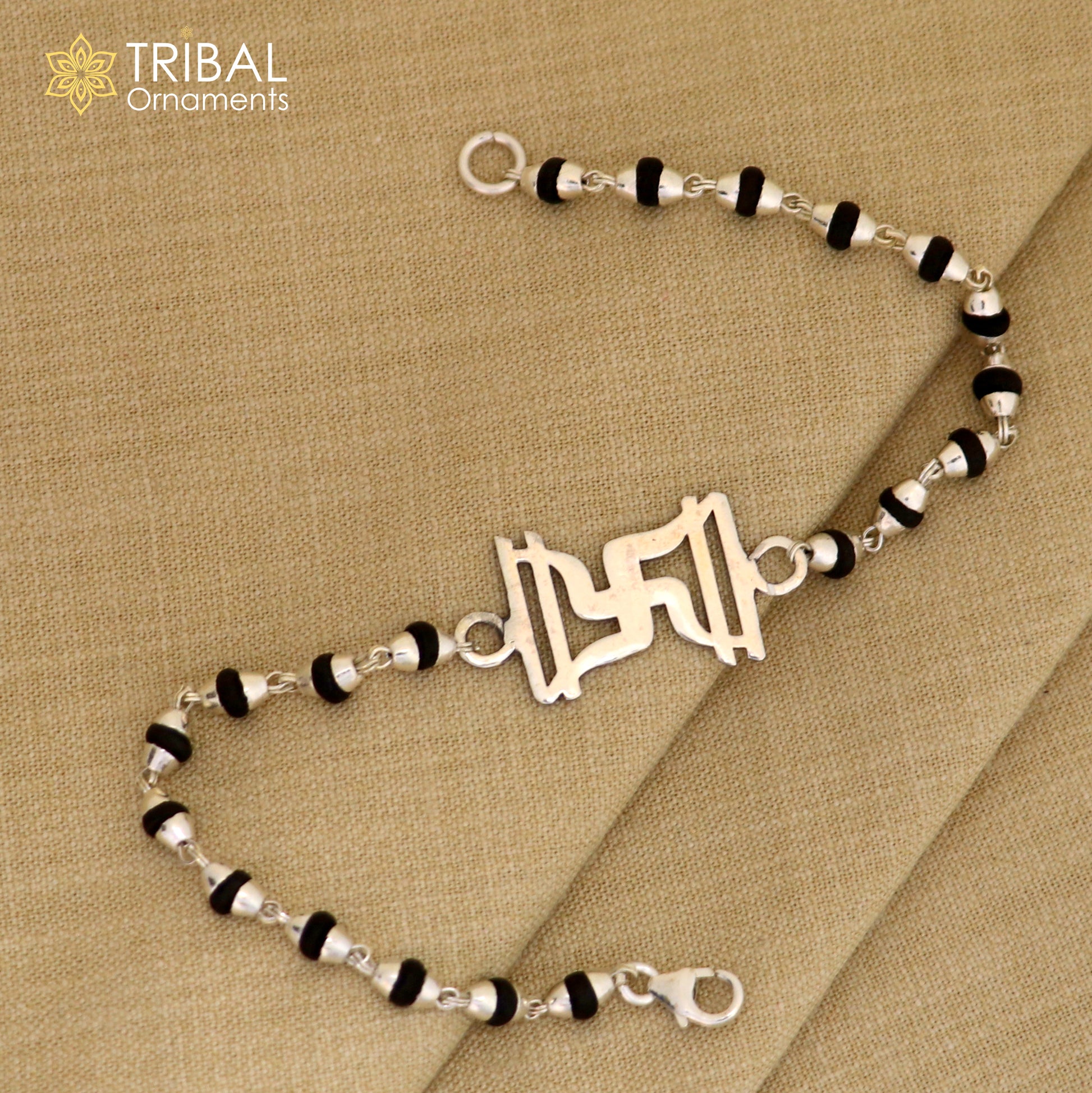 Sterling silver Swastik design Rudraksha and black Tulsi beads bracelet rakhi with silver beads and chain, handcrafted by TRIBAL ORNAMENTS.