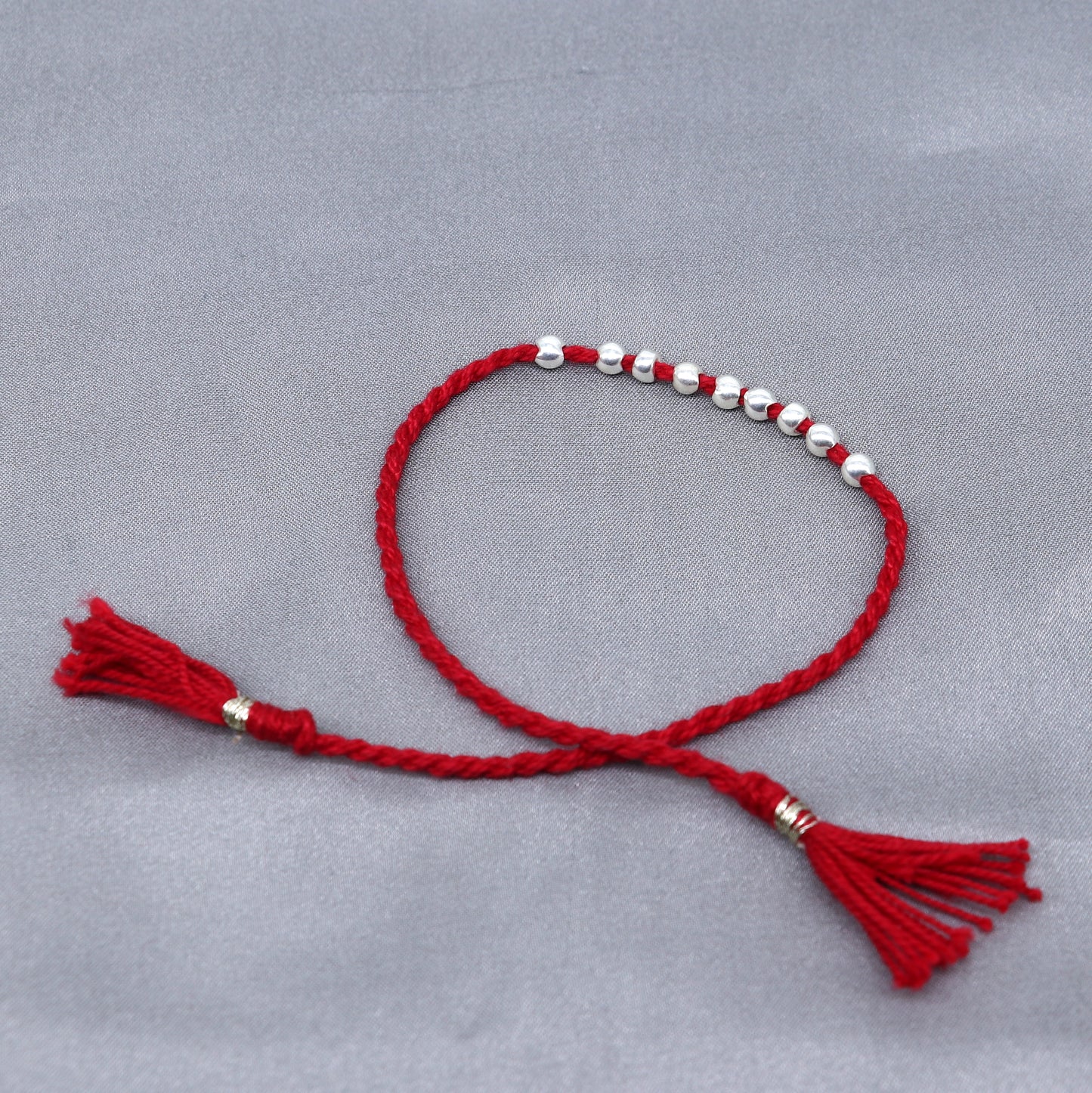 925 sterling silver ball design thread rakhi bracelet by TRIBAL ORNAMENTS with traditional decorative elements for Rakshabandhan.
