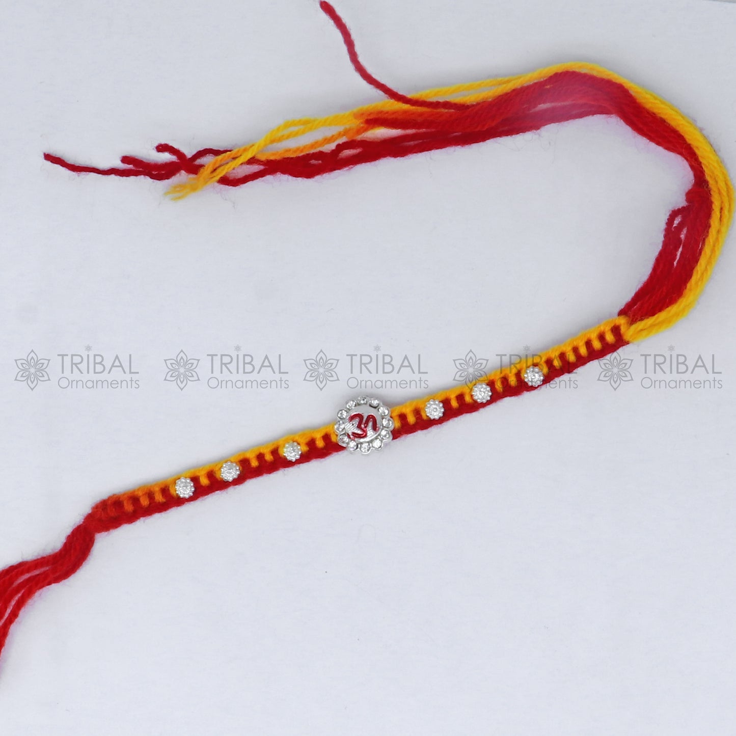 Sterling silver Om design thread rakhi bracelet from TRIBAL ORNAMENTS with intricate Om pendant for Rakshabandhan festival.