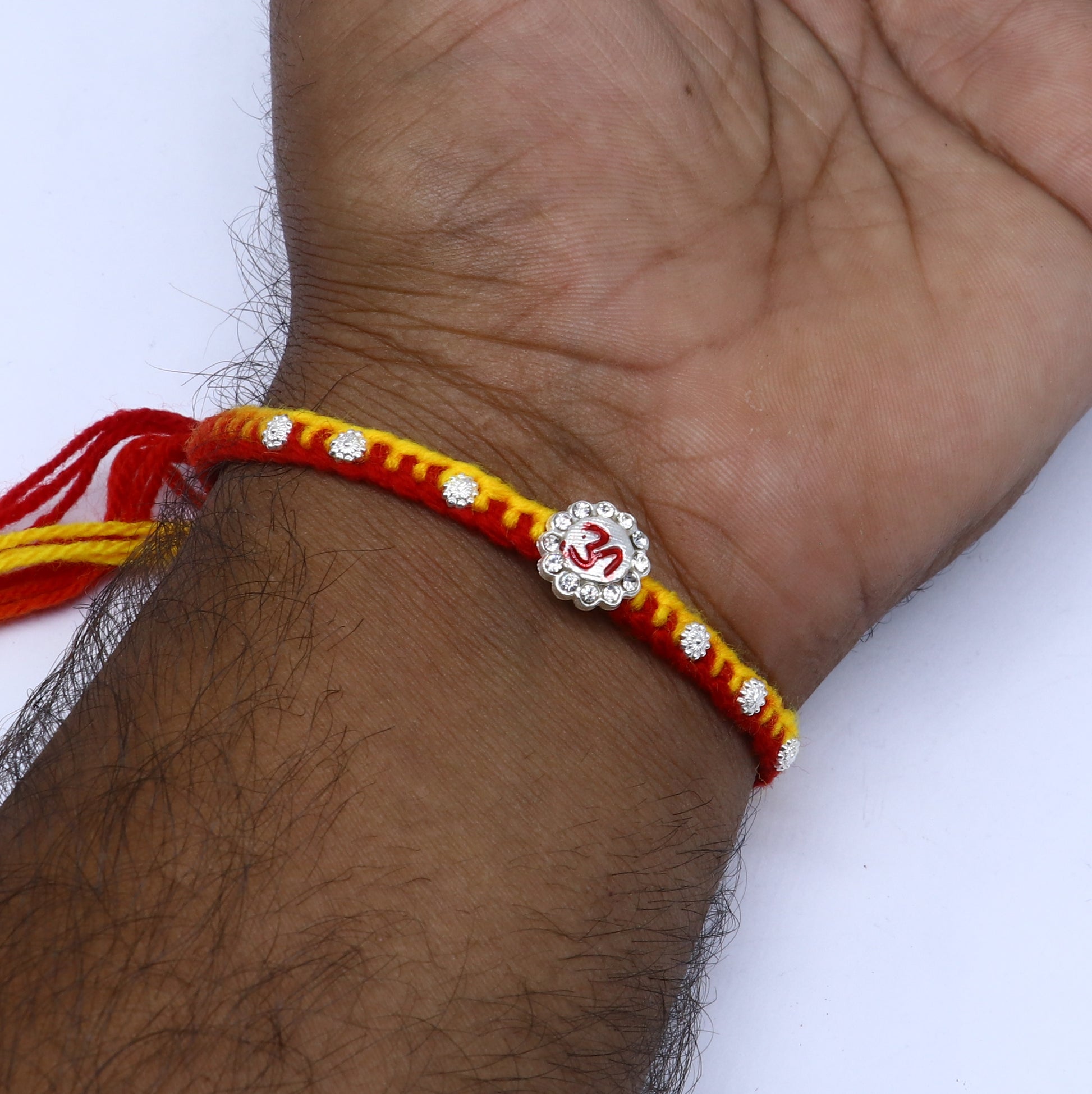 Sterling silver Om design thread rakhi bracelet by TRIBAL ORNAMENTS with intricate Om pendant for Rakshabandhan festival.