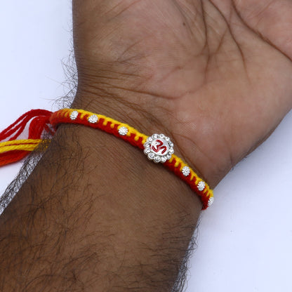 Sterling silver Om design thread rakhi bracelet by TRIBAL ORNAMENTS with intricate Om pendant for Rakshabandhan festival.
