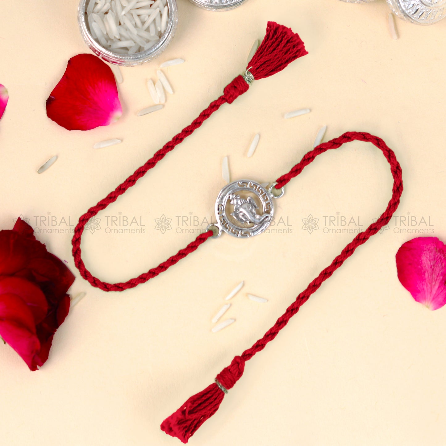 Sterling silver Ganesha design thread bracelet with red thread, crafted by TRIBAL ORNAMENTS, featuring intricate pendant details.