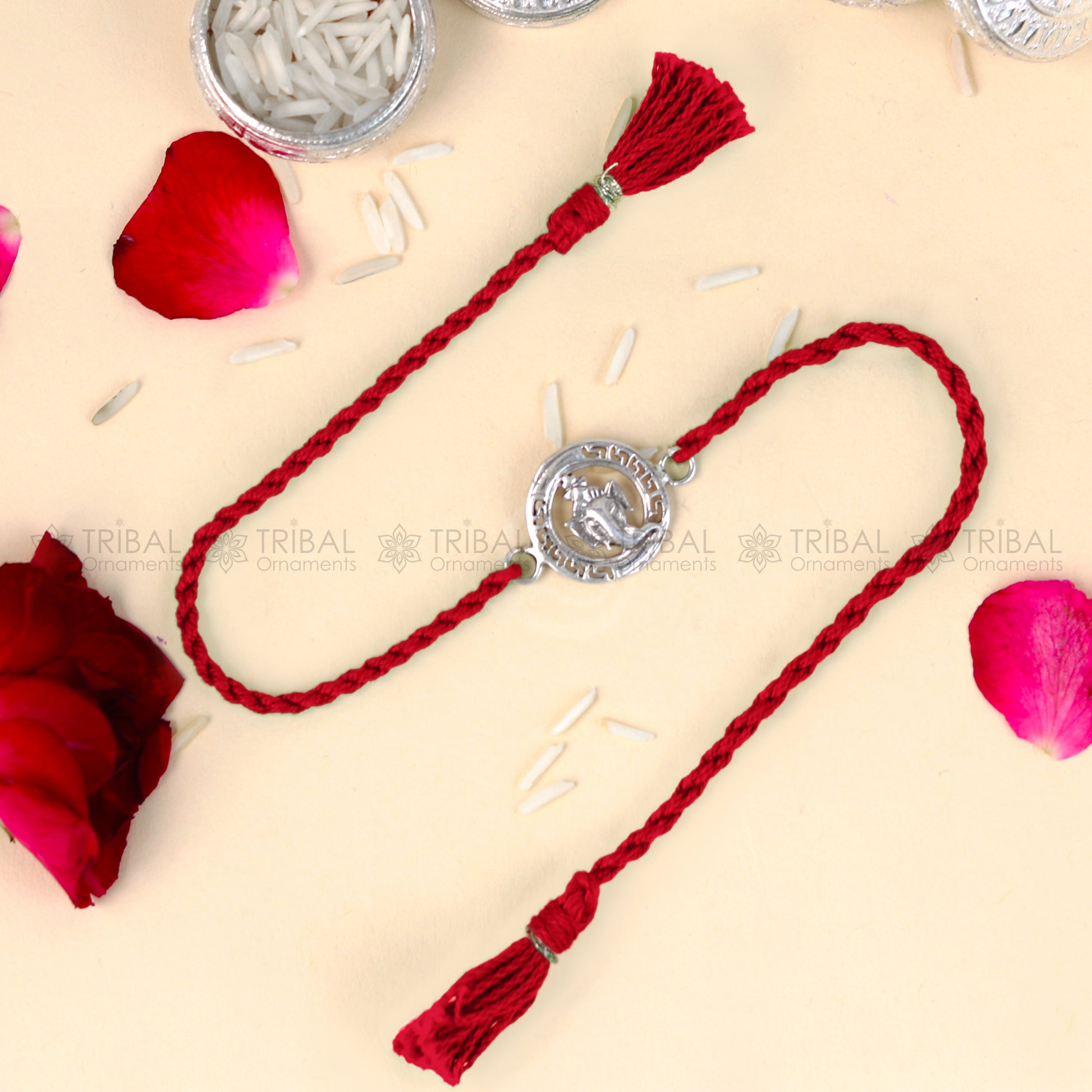 Sterling silver Ganesha design thread bracelet with red thread, crafted by TRIBAL ORNAMENTS, featuring intricate pendant details.