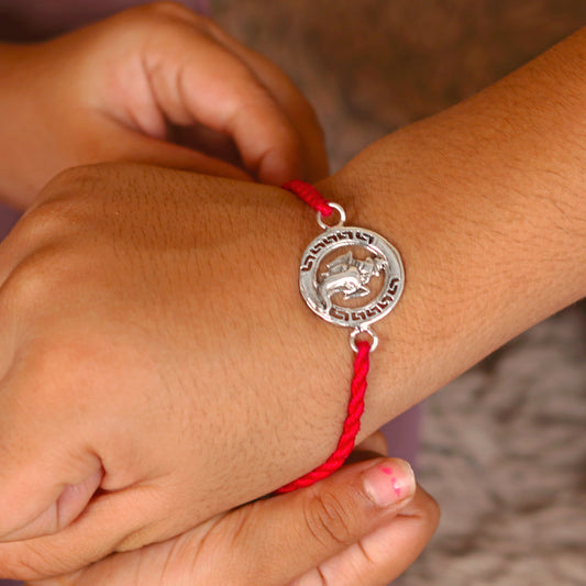 Sterling silver Ganesha design thread bracelet with red thread from TRIBAL ORNAMENTS, featuring a detailed elephant pendant.