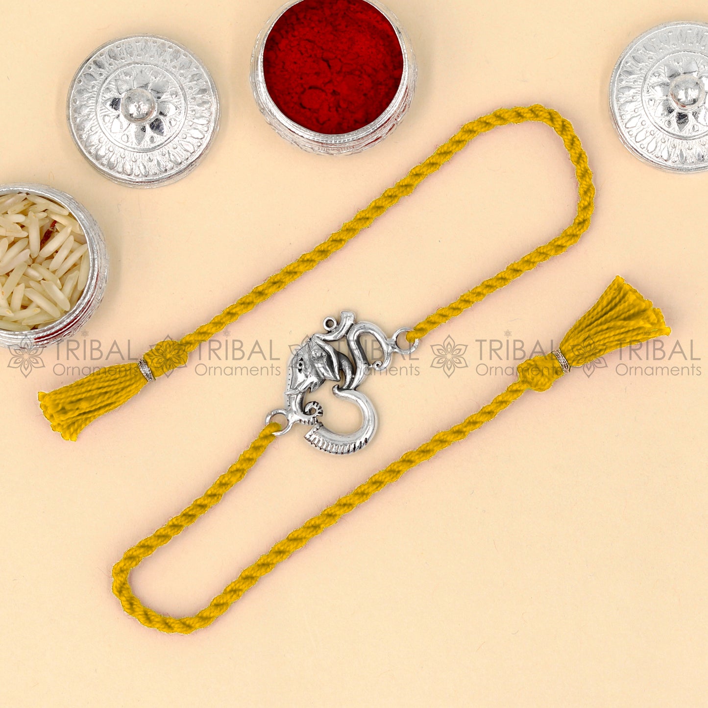 Sterling silver Ganesha Om design thread bracelet with red thread, featuring intricate tribal ornament pendant, ideal for rakhi.