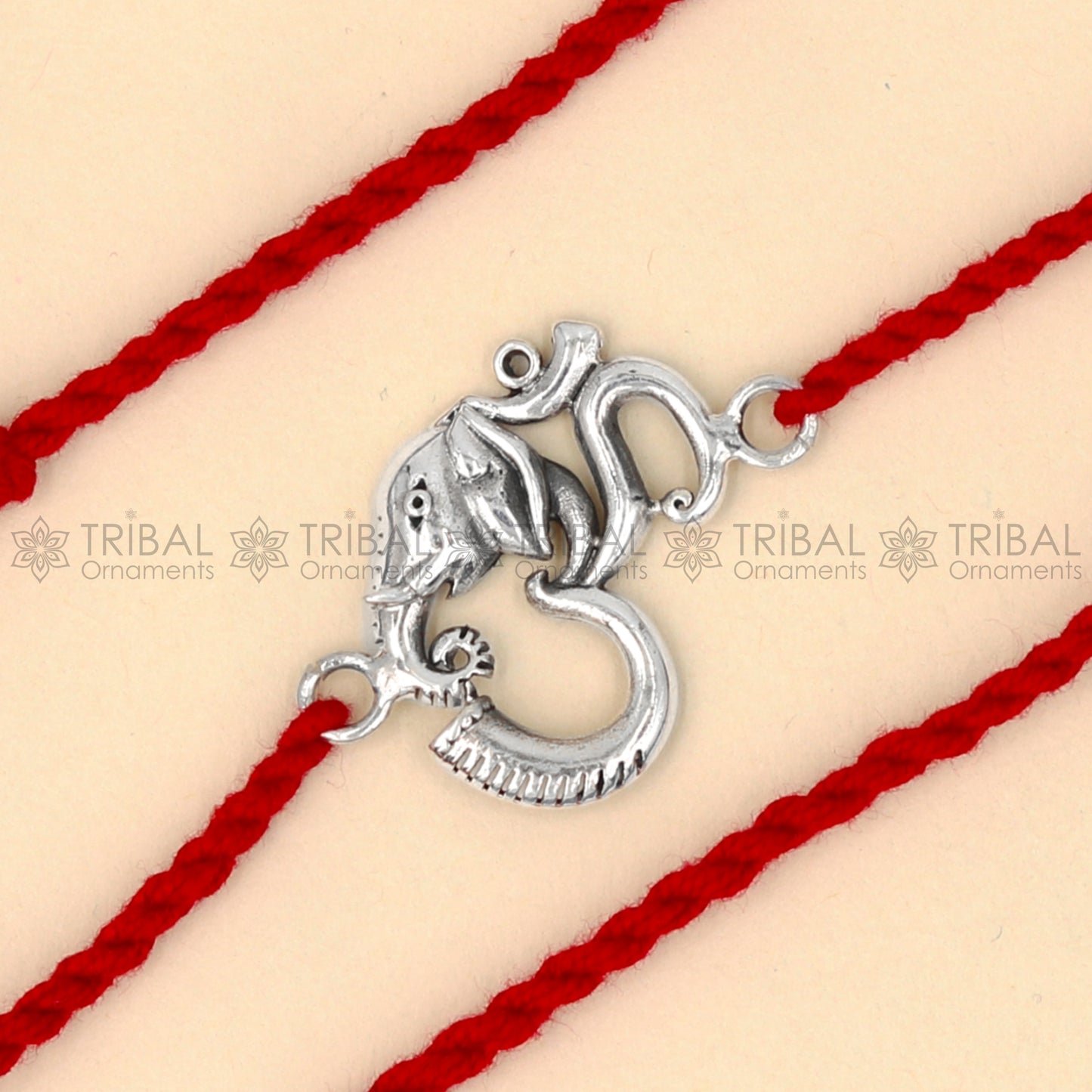 925 Sterling silver Ganesha Om design thread bracelet with red thread from TRIBAL ORNAMENTS, featuring a detailed Ganesha pendant.