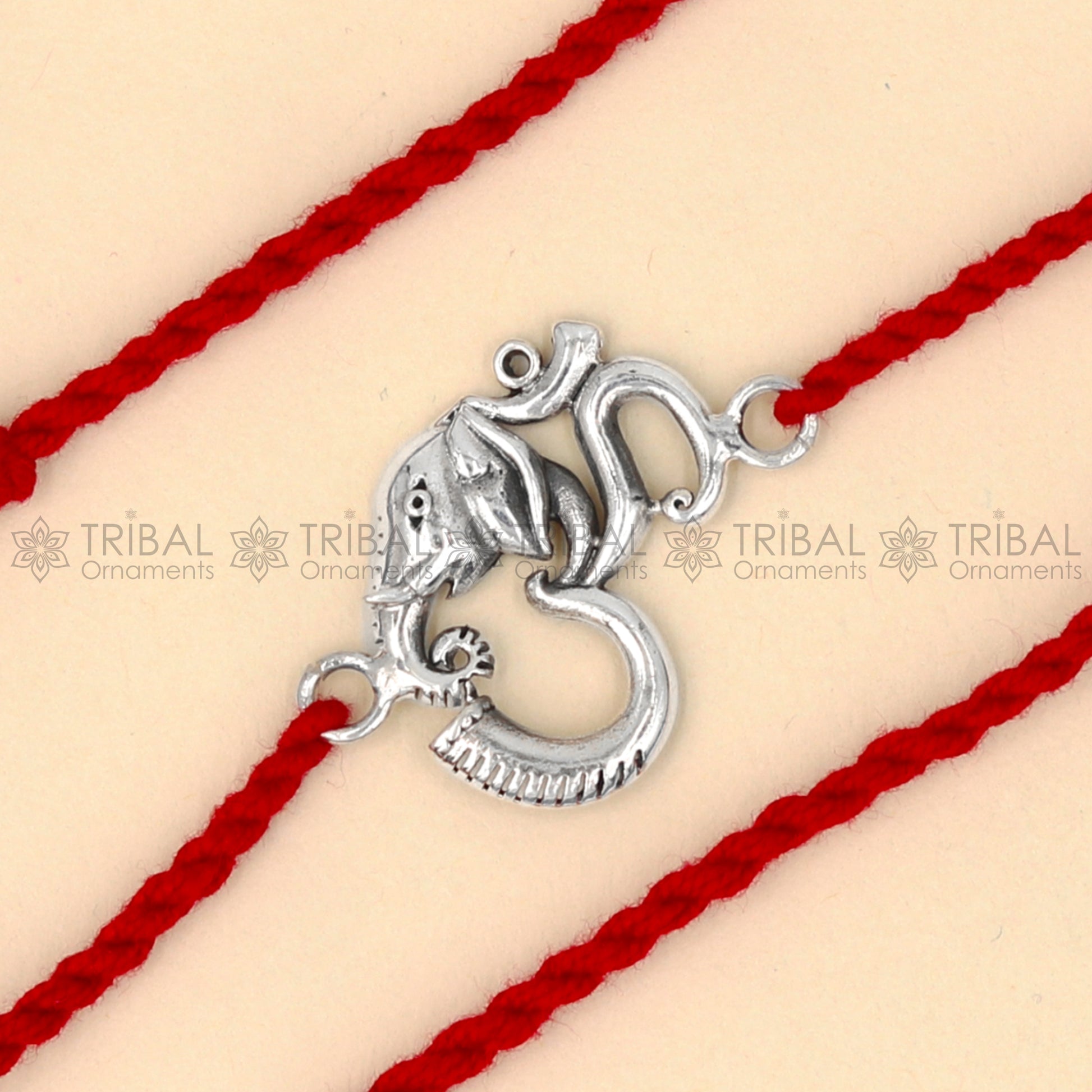 925 Sterling silver Ganesha Om design thread bracelet with red thread from TRIBAL ORNAMENTS, featuring a detailed Ganesha pendant.