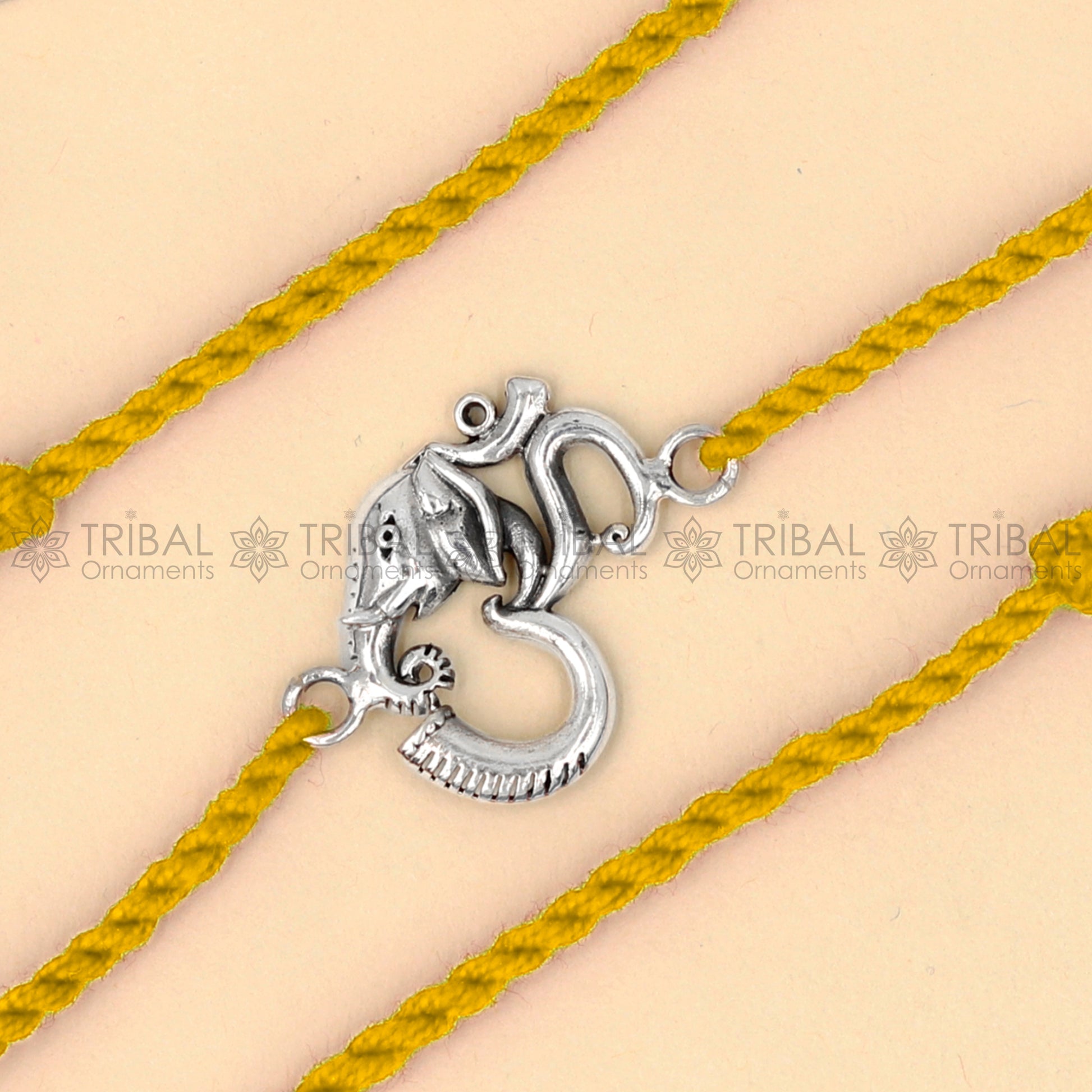 925 Sterling silver Ganesha Om design thread bracelet with red thread by TRIBAL ORNAMENTS featuring a detailed pendant design.