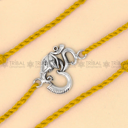 925 Sterling silver Ganesha Om design thread bracelet with red thread by TRIBAL ORNAMENTS featuring a detailed pendant design.