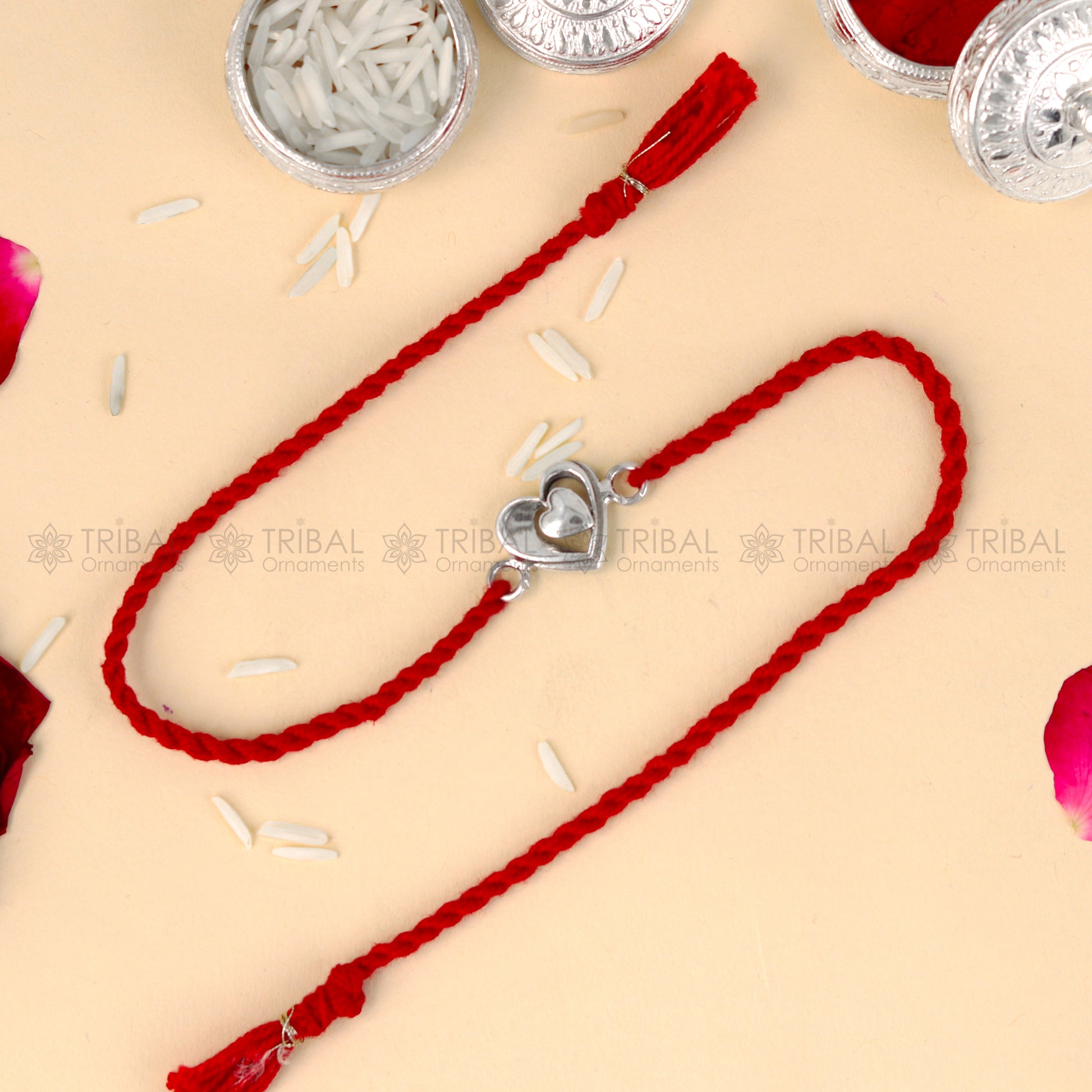 925 Sterling silver heart design thread rakhi bracelet with red thread from TRIBAL ORNAMENTS, featuring a silver heart pendant.