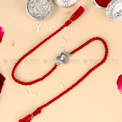 925 Sterling silver heart design thread rakhi bracelet with red thread from TRIBAL ORNAMENTS, featuring a silver heart pendant.