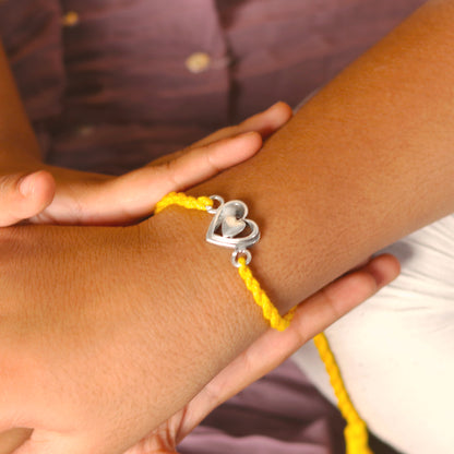 925 Sterling silver heart design thread rakhi bracelet by TRIBAL ORNAMENTS with red thread and silver heart pendant.