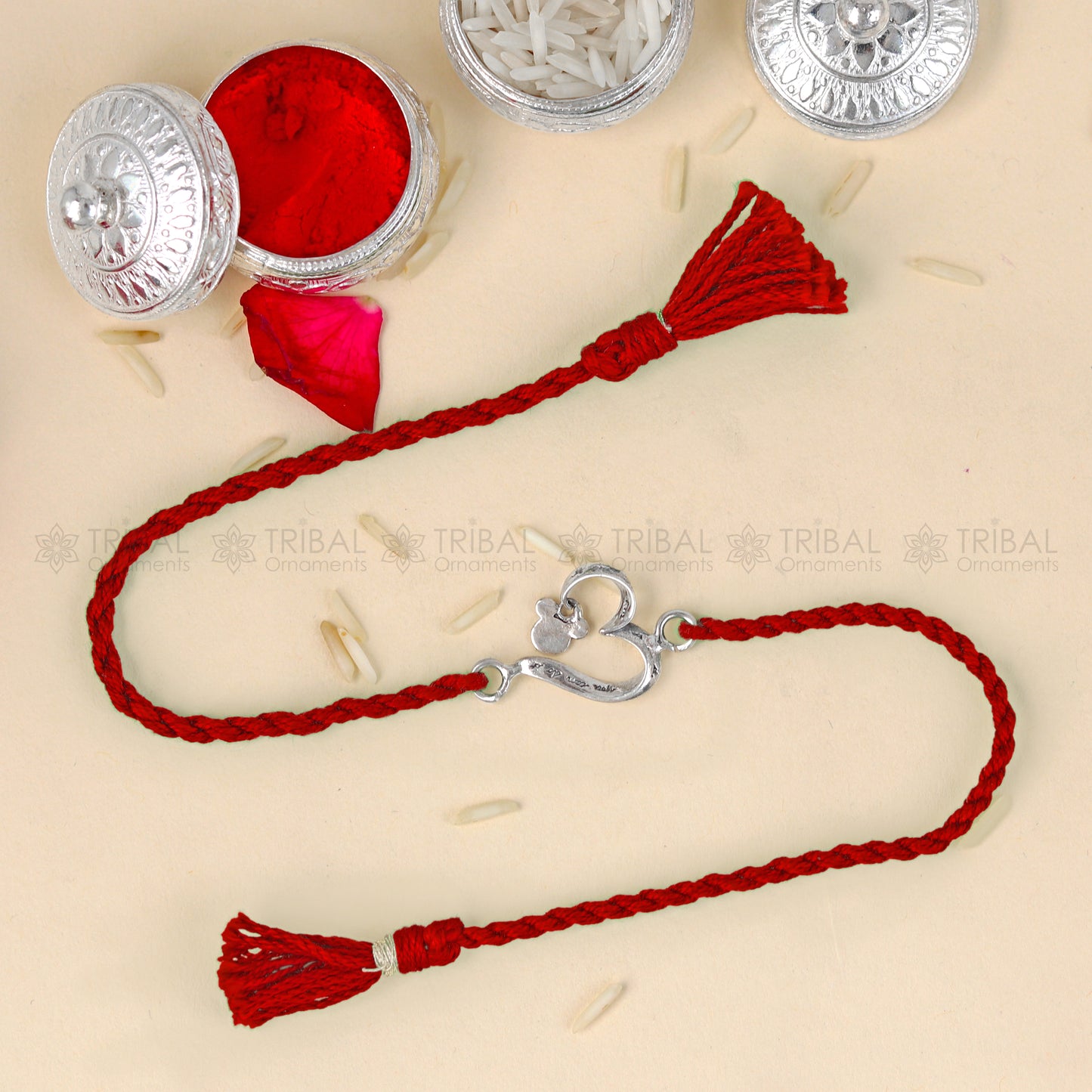 Sterling silver heart design thread bracelet by Tribal Ornaments with red thread and silver pendant.