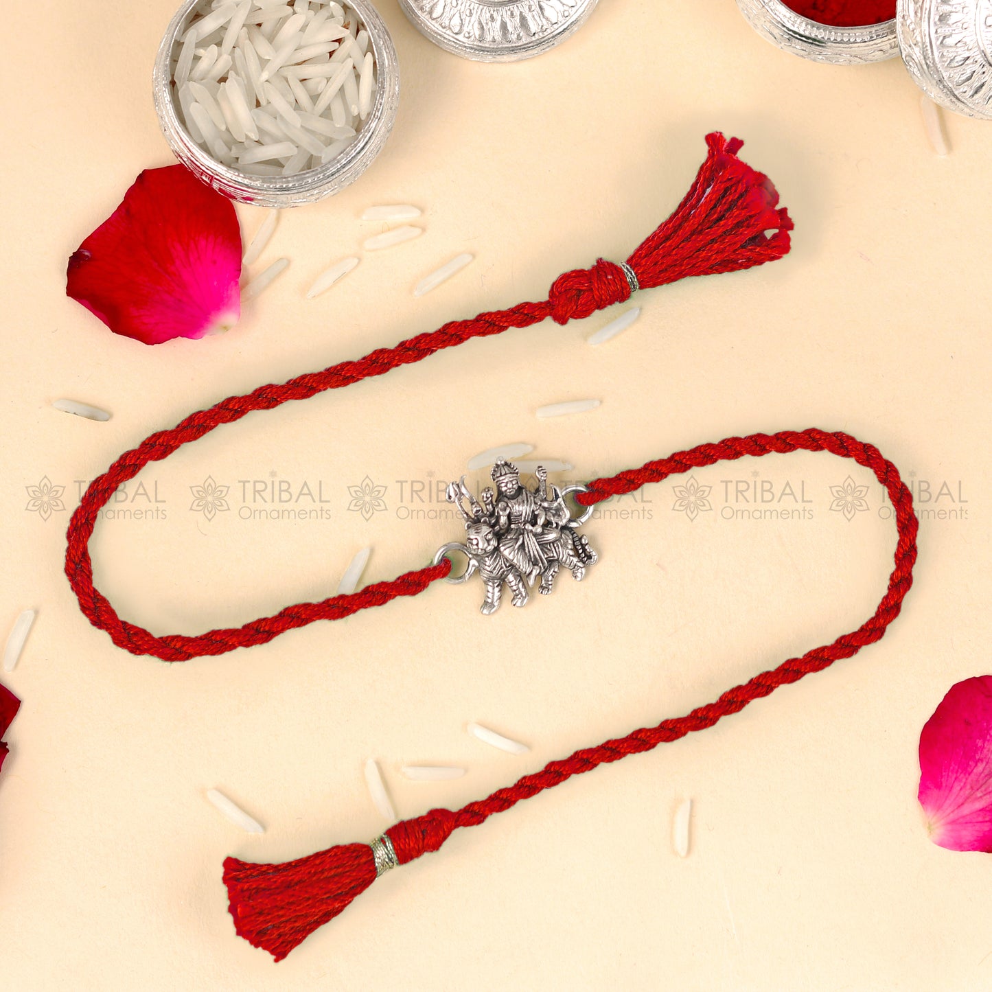 Sterling silver Lord Durga Maa design thread rakhi bracelet with red thread from TRIBAL ORNAMENTS, featuring intricate pendant design.