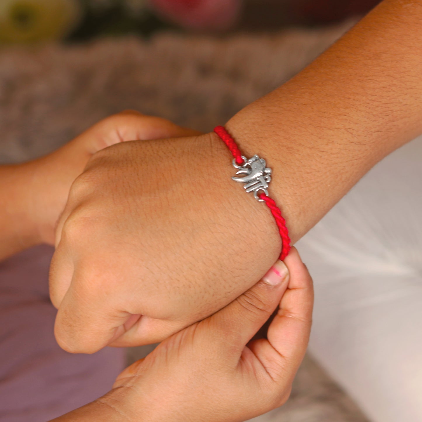 925 Sterling silver Lord Ganesha thread bracelet by TRIBAL ORNAMENTS with red thread and Ganesha pendant design.
