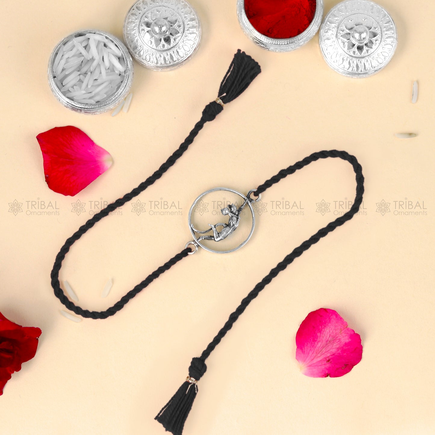 Sterling silver Lord Hanuman design thread rakhi bracelet with red thread from TRIBAL ORNAMENTS, featuring intricate pendant details.