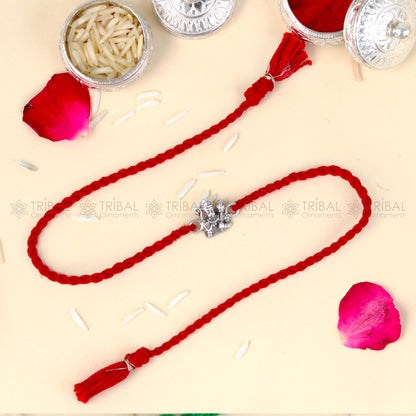 Sterling silver Lord Hanuman ji design thread rakhi bracelet with red thread from TRIBAL ORNAMENTS, featuring intricate pendant details.