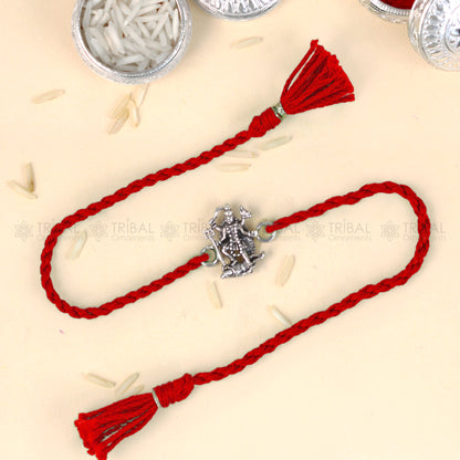 Sterling silver Lord Kali Maa and Shiv Ji design thread rakhi bracelet from Tribal Ornaments with red thread and intricate silver detailing.