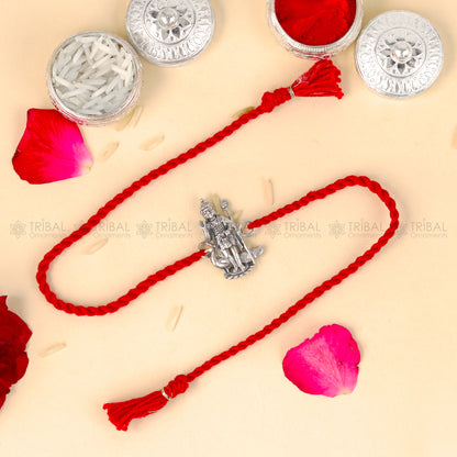 Sterling silver Lord Karthikeya design thread rakhi bracelet with red thread from TRIBAL ORNAMENTS featuring a detailed pendant.