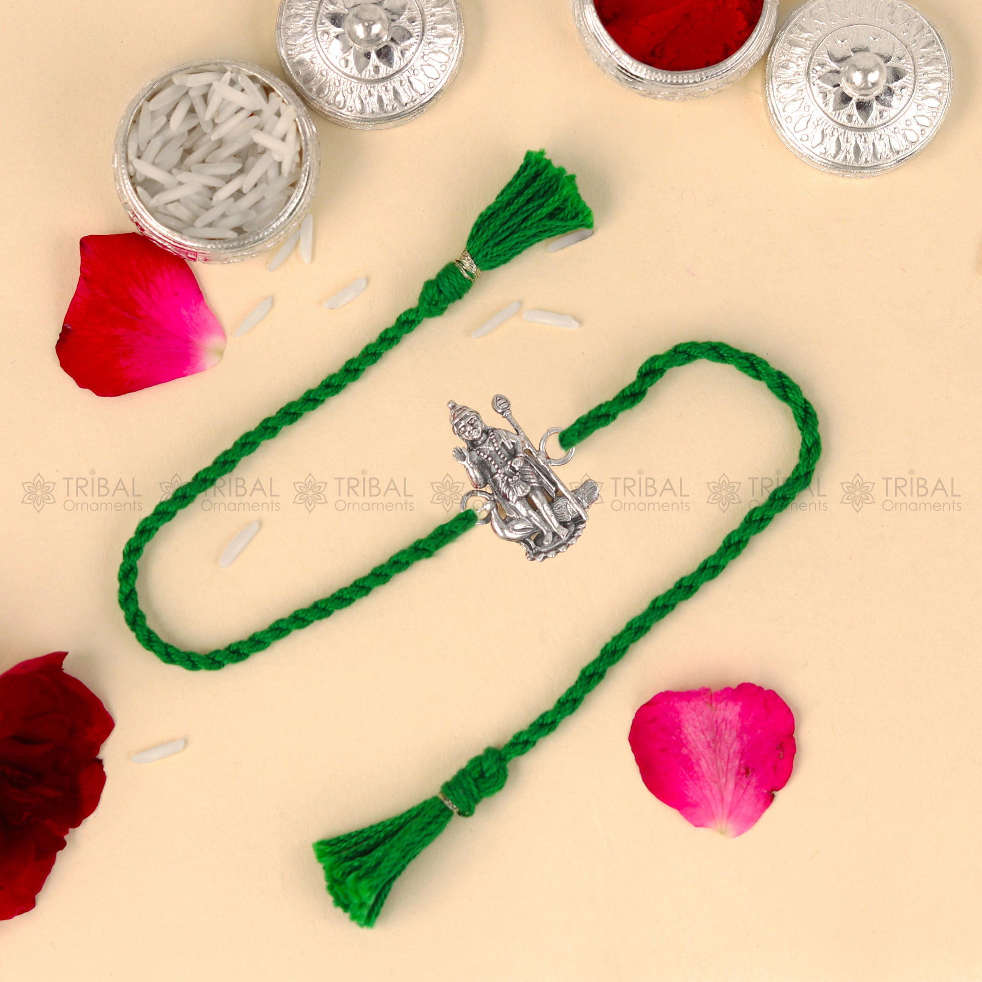 Sterling silver Lord Karthikeya thread bracelet by TRIBAL ORNAMENTS with red thread and detailed pendant design.
