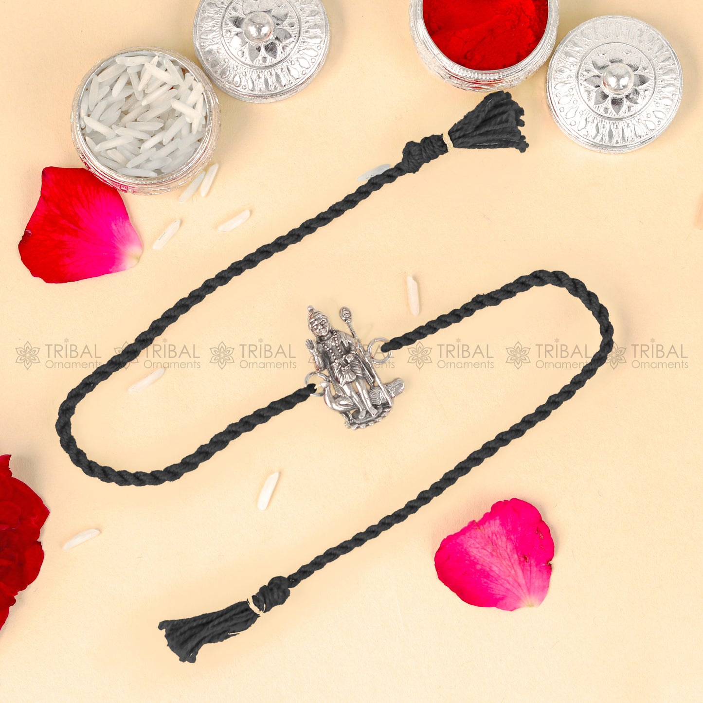Sterling silver Lord Karthikeya design thread rakhi bracelet with red thread from TRIBAL ORNAMENTS, featuring a detailed pendant.