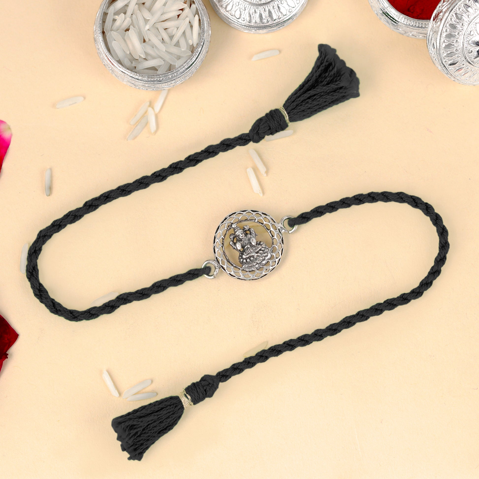 925 Sterling silver Lord Laxmi ji design thread rakhi bracelet with red thread from TRIBAL ORNAMENTS, featuring intricate pendant details.