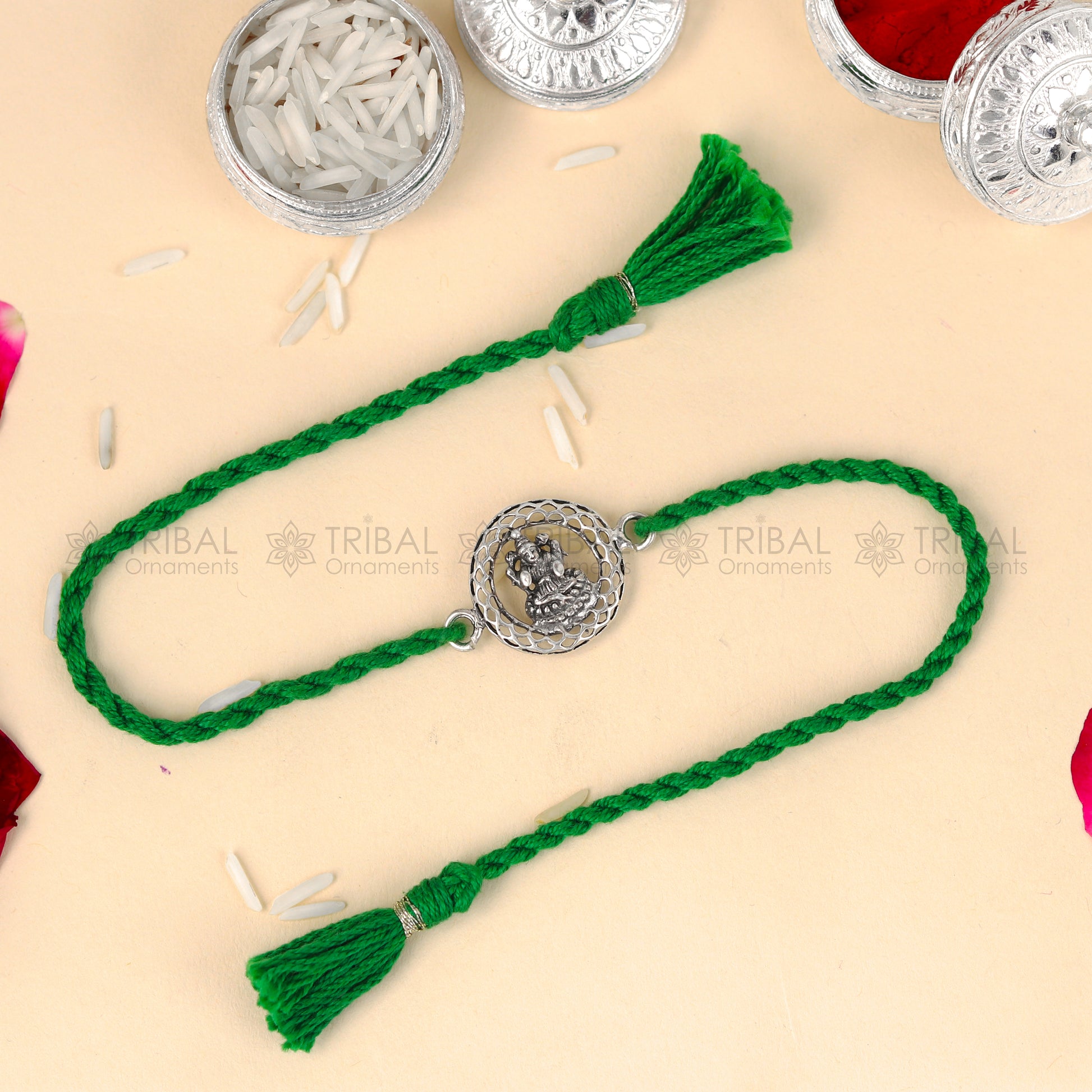 Sterling silver Lord Laxmi ji design thread rakhi bracelet with red thread from TRIBAL ORNAMENTS featuring a decorative pendant.