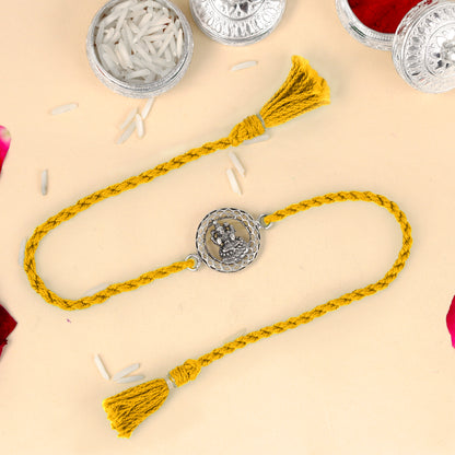 Sterling silver Lord Laxmi Ji design thread rakhi bracelet with red thread from TRIBAL ORNAMENTS, featuring intricate pendant.
