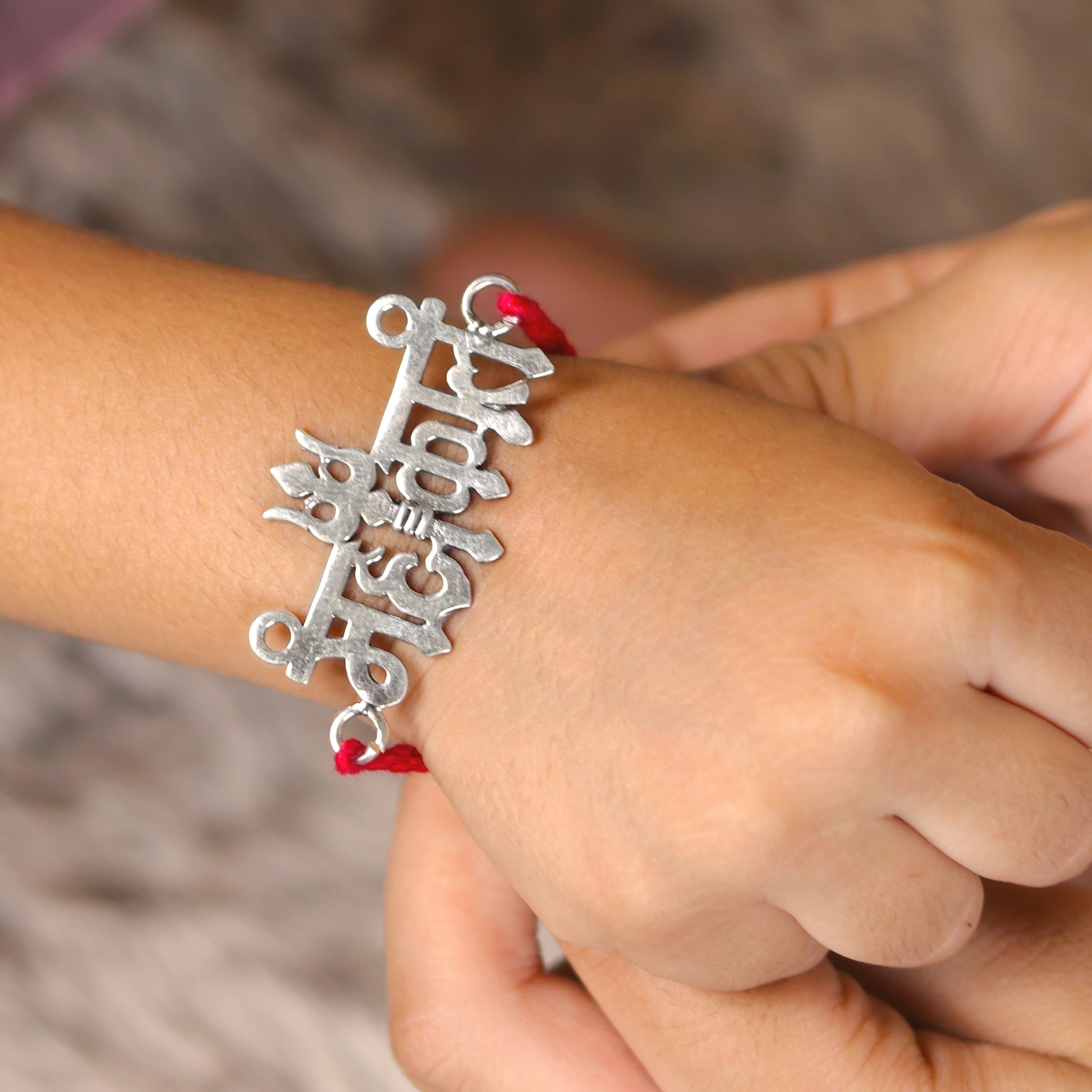 925 Sterling silver Lord Mahakal design thread rakhi bracelet with red thread and silver pendant from Tribal Ornaments.