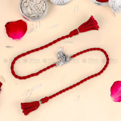 Sterling silver Lord Om Sai Ram thread bracelet by Tribal Ornaments with red thread and Om Sai Ram pendant.
