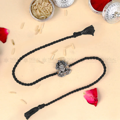 925 Sterling silver Lord Shiva design thread rakhi bracelet with red thread from TRIBAL ORNAMENTS, featuring intricate Shiva figure.