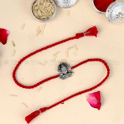 Sterling silver Lord Shiva design thread bracelet by TRIBAL ORNAMENTS with red thread accents and intricate silver detailing.