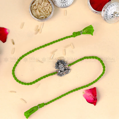 925 Sterling silver Lord Shiva design thread rakhi bracelet with red thread from TRIBAL ORNAMENTS, featuring intricate silver detailing.