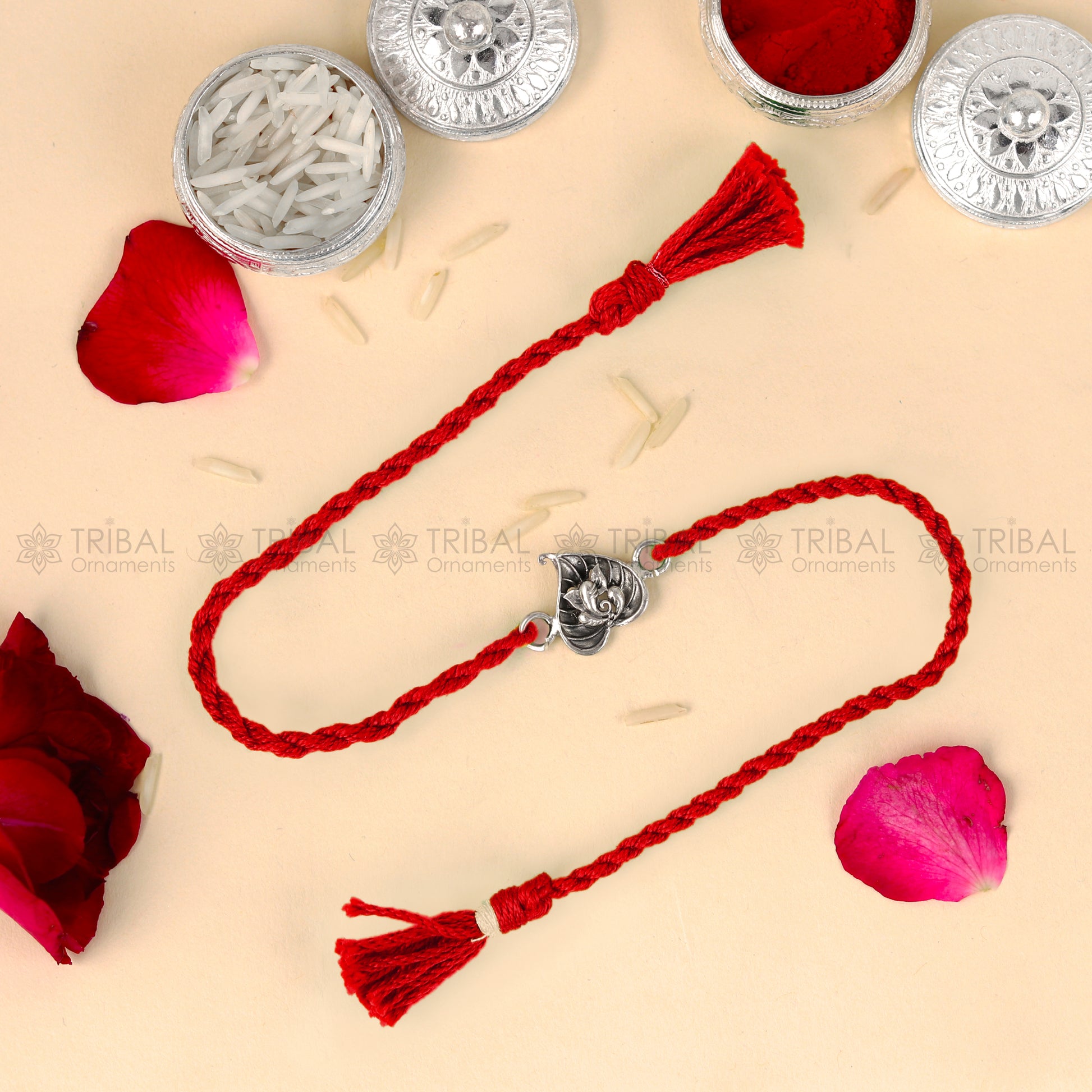 Sterling silver Lord Ganesha bracelet with red thread and pan design pendant from TRIBAL ORNAMENTS, traditional Rakhi accessory