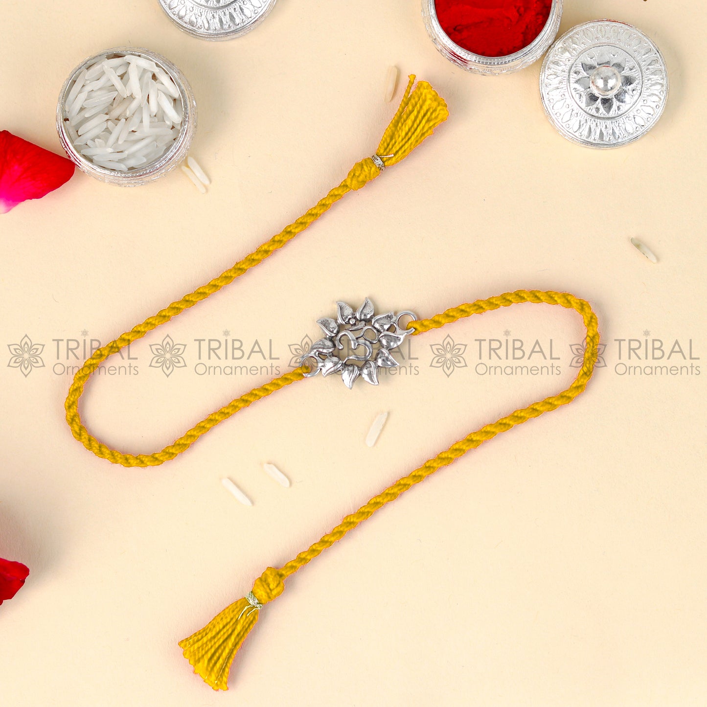 Sterling silver OM design thread bracelet by TRIBAL ORNAMENTS with red thread and pendant, featuring intricate silver detailing.