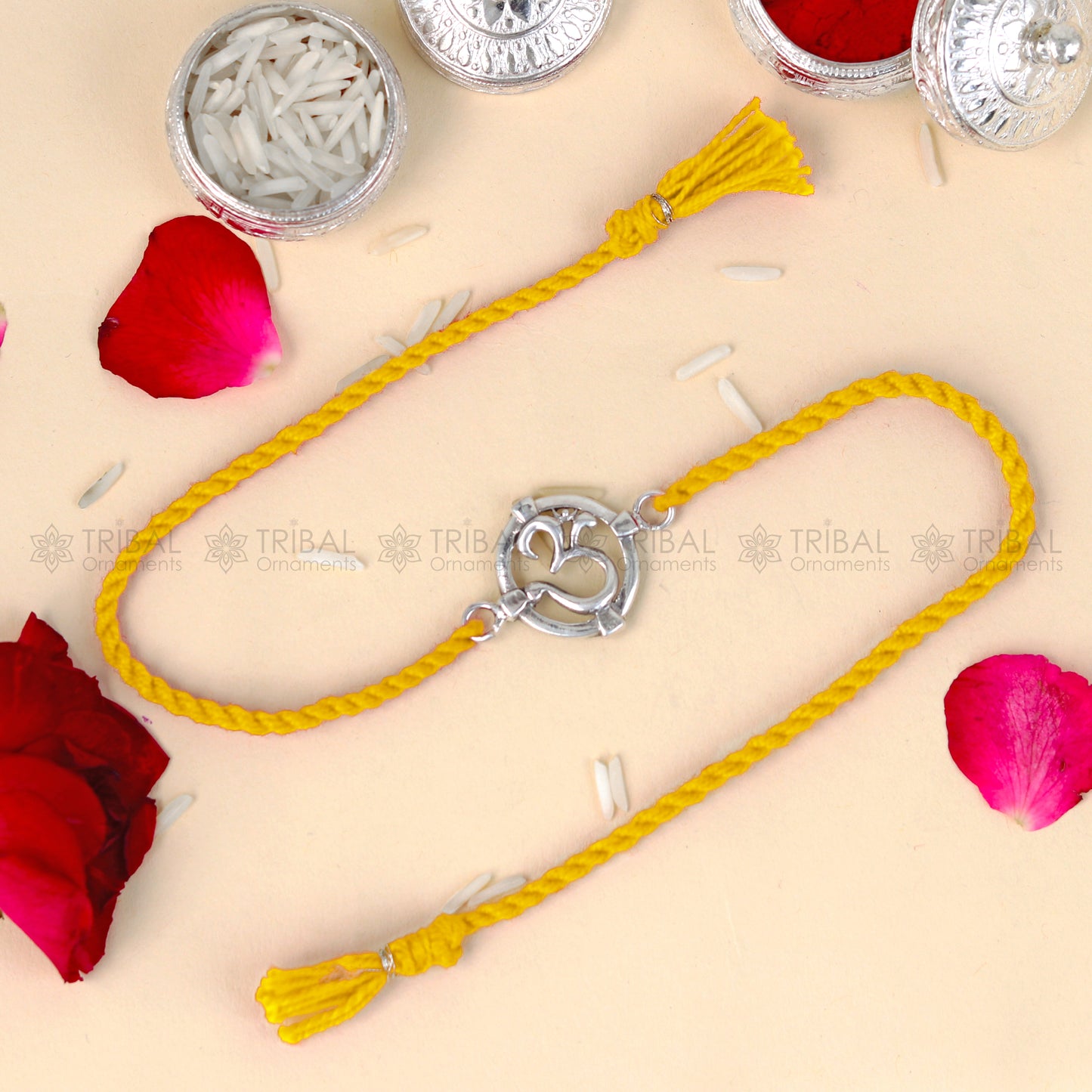 Sterling silver Om design thread bracelet by Tribal Ornaments with red thread and silver pendant, handcrafted jewelry.