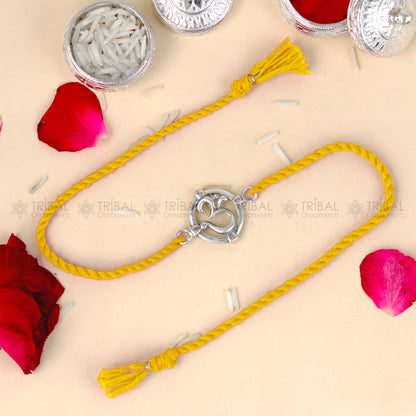 Sterling silver Om design thread bracelet by Tribal Ornaments with red thread and silver pendant, handcrafted jewelry.
